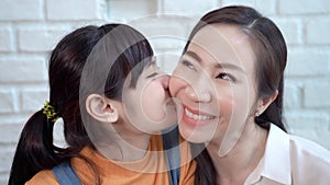 Asian teenage daughter kissing mother, showing love between mother and daughter