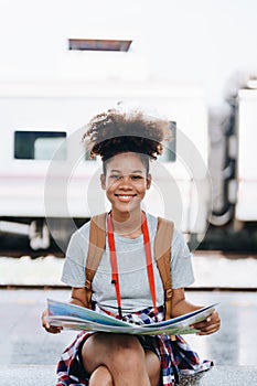 Asian teenage girl african american traveler dressed in casual wear holding map and searching right direction of route