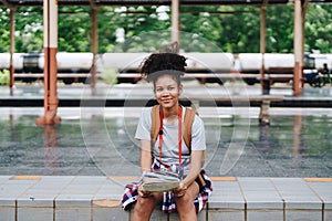 Asian teenage girl african american traveler dressed in casual wear holding map and searching right direction of route