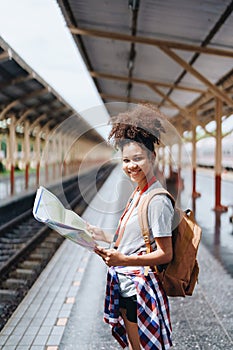 Asian teenage girl african american traveler dressed in casual wear holding map and searching right direction of route