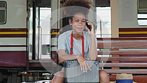 Asian teenage girl african american traveling using smartphone moblie while waiting for a train at a station.