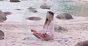 Asian teenage girl in casual wear are meditating sitting close the bith. Young woman doing yoga exercise for stress