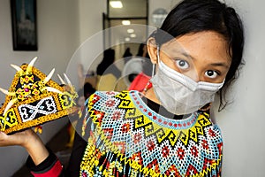 Asian teenage girl in colorful traditional costume preparing for dance performance