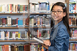 Asian teenage girl with eyeglasses in school library