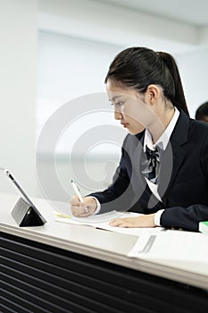 Asian teenage girl studying with the assistance of a mobile phone