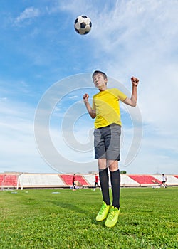 Asian teenager boy in a football stadium, practicing. Jump and