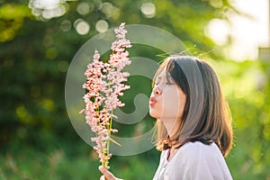 Asian teenager girl blower grass flower with sun