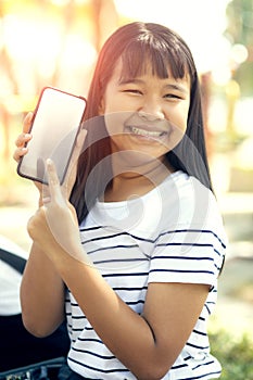 Asian teenager show white screen of smart phone screen and toothy smiling face happiness emotion