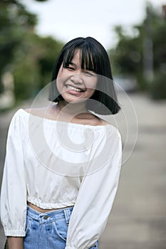 Asian teenager sitting on stack of contruction brick