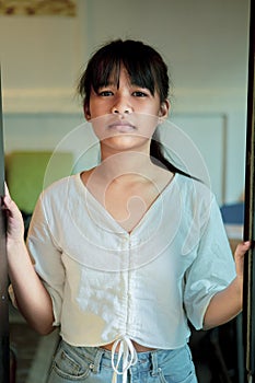 Asian teenager standing at home with calm in face