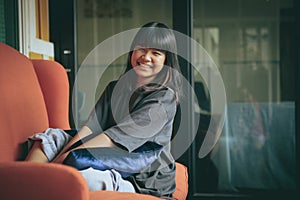Asian teenager toothy smiling face ,relaxing in home living room
