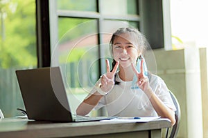 Asian teenager working on computer destop toothy smiling face