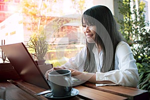 Asian teenager working on laptop at home living terrace