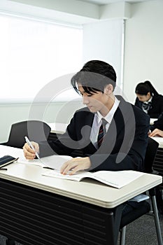 Asian teenagers in high school uniform studying in class