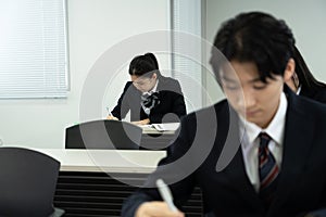 Asian teenagers in high school uniform studying in class