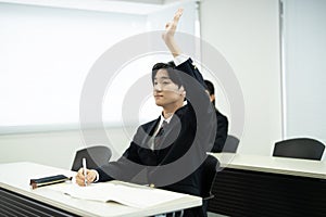 Asian teenagers in high school uniforms studying in class