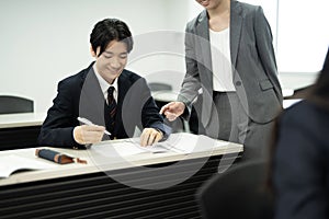 Asian teenagers in high school uniforms studying in class