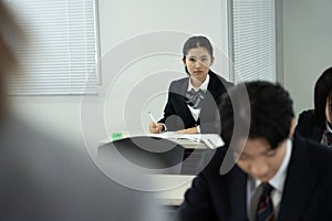 Asian teenagers in high school uniforms studying in class