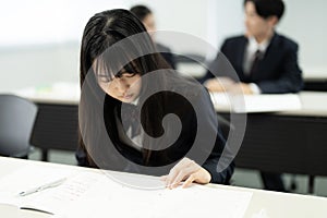 Asian teenagers in high school uniforms studying in the class
