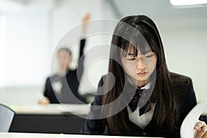 Asian teenagers in high school uniforms studying in the class