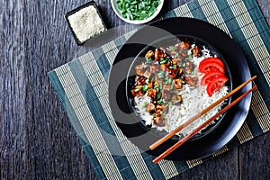 Asian teriyaki tofu with rice in a bowl, flat lay