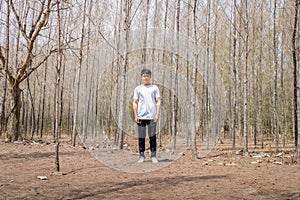 Asian Thai man in white casual stands alone in dry pie forest
