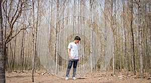 Asian Thai man in white casual stands alone in dry pie forest