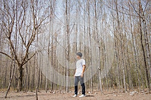 Asian Thai man in white casual stands alone in dry pie forest