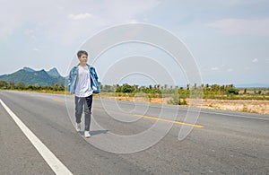 Asian Thai man in white casual stands alone on the empty road