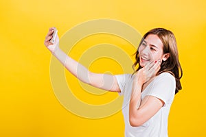 Woman teen smiling standing wear t-shirt making selfie photo, video call on smartphone