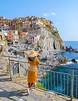 Asian Thai women with a hat visiting Manarola Village Cinque Terre Coast Italy during summer