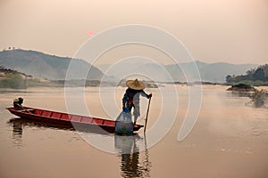Asian,Thailand fisherman cacth fish on the wooden boath in meko