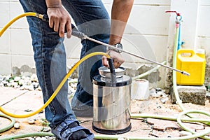 Asian Thailand termite staff company is spraying the destroy chemical liquid in to white ant nest in the wood around human house