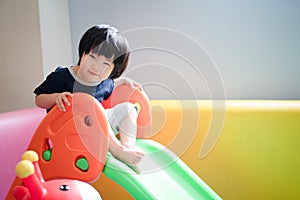 Asian toddler baby boy girl looking toward camera with a little smile