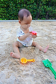 Asian toddler baby thai girl playing with sand