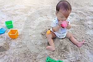 Asian toddler baby thai girl playing with sand