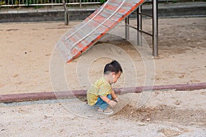 asian toddler boy playing in outdoor playground