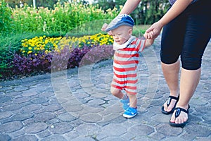 Asian toddler boy walking with his mother, Baby first step concept