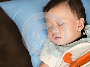 Asian toddler fell into a slumber on bed.