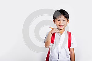 Asian toddler smiling happy wear student thai uniform red pants holding pencil for writers notebook