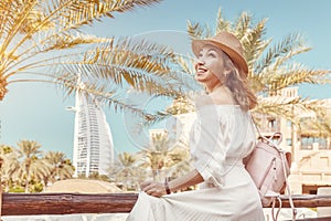 Asian tourist girl with the famous Burj al Arab hotel building in Dubai. Tourism in United Arab Emirates