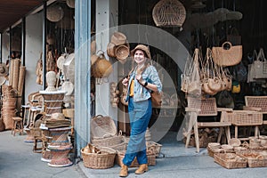 Asian tourist girl shopping, walking in famous local street market looking at beautiful straw hats, happy shopping at