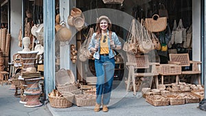 Asian tourist girl shopping, walking in famous local street market looking at beautiful straw hats, happy shopping at