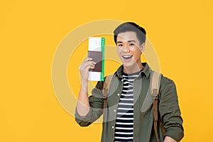 Asian tourist man smiling and holding passport with boarding pass