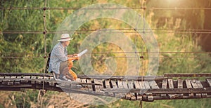 Asian tourist man walking on the old and broken wood bridge