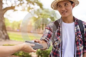 Asian tourist picking up his black wallet from other people that they found in tourist attraction