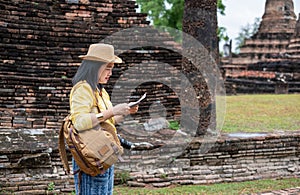 Asian tourist woman see map at ancient of pagoda temple thai architecture at Sukhothai,Thailand. Female traveler in casual thai