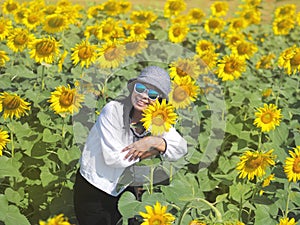 Asian tourist woman standing in yellow sunflowers farm