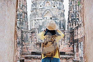 Asian tourist woman take a photo of ancient of pagoda temple thai architecture at Sukhothai,Thailand. Female traveler in casual