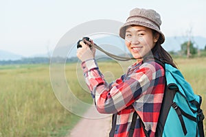 Asian tourist woman taking photo by digital camera on nature mountain view. A young girl is traveling on summer vacation